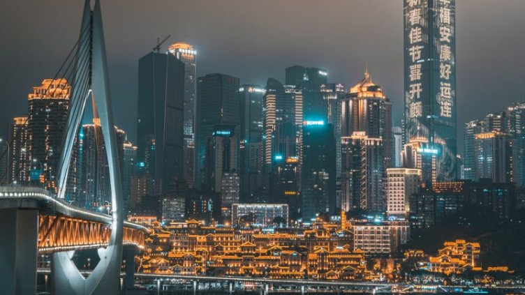 Chongqing skyline at night with a bridge and HongyaDong cave