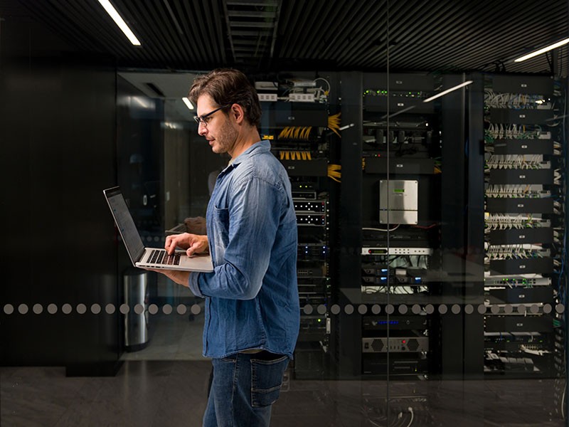 Man walking inside a room with laptop