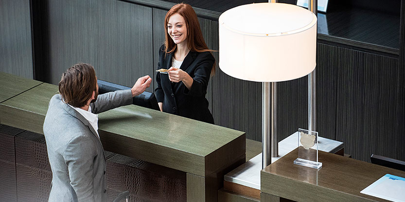 Female receptionist giving credit card to businessman 