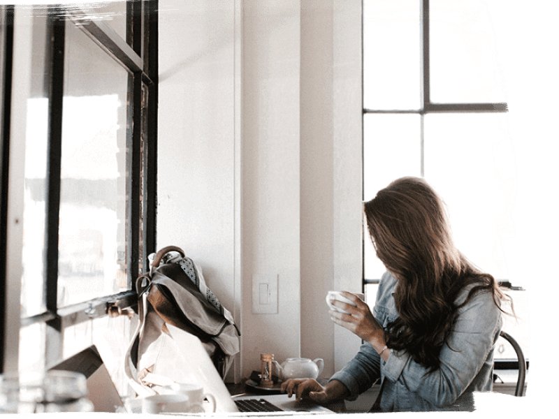 Lady working on Laptop with cup of coffee