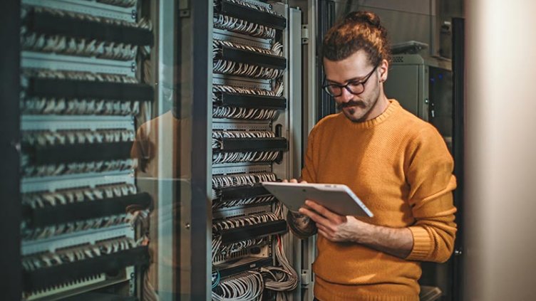 Man working on a tablet in a data center