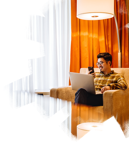 A man working while sitting inside a hotel room